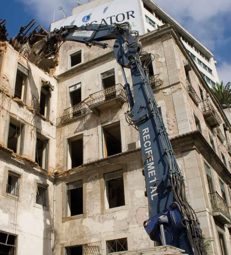 Demolición urbana de un edificio con retroexcavadora de largo alcance