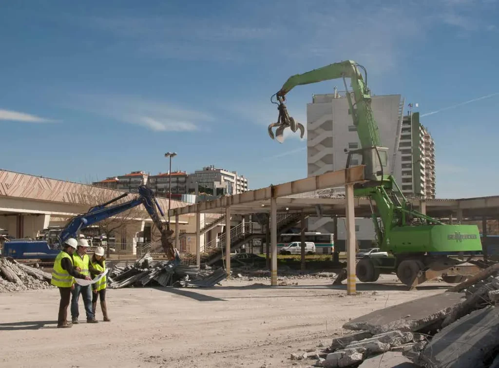 Técnicos supervisando la seguridad en una obra de demolición con maquinaria